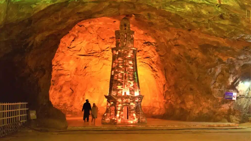 Khewra Salt Mine - a small, brick tower partially made of salt, glowing with warm light.